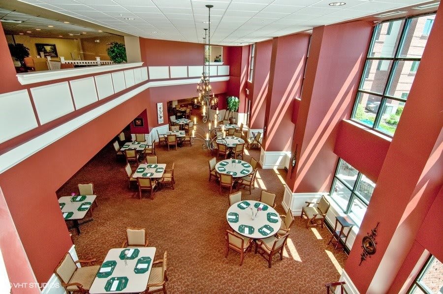 A spacious restaurant dining area with tables and chairs, featuring large windows providing ample natural light.
