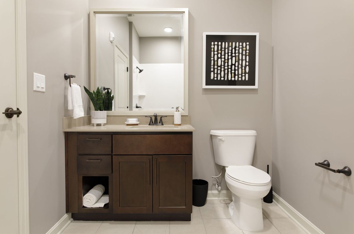 Modern bathroom with a vanity, mirror, and toilet.