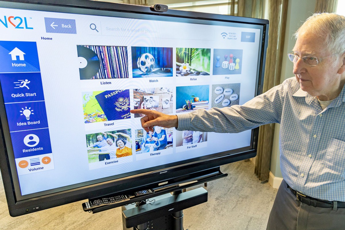A person interacts with a touchscreen display during a presentation.