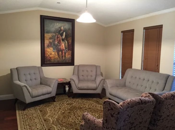 A cozy living room with comfortable seating and a large painting on the wall.