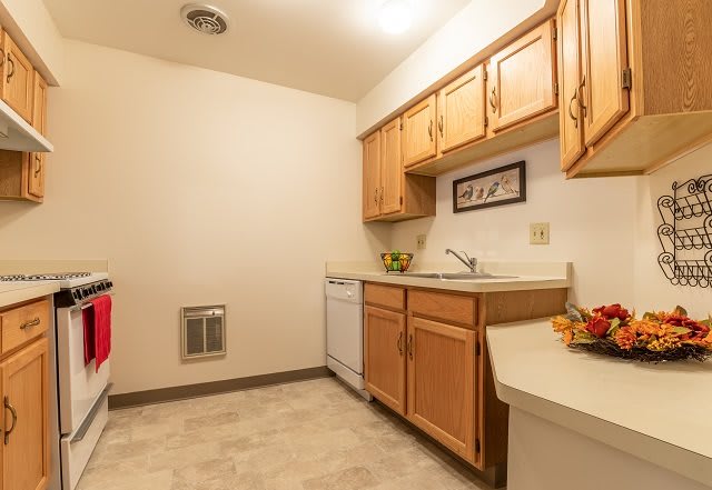 A small kitchen with wooden cabinets and modern appliances.