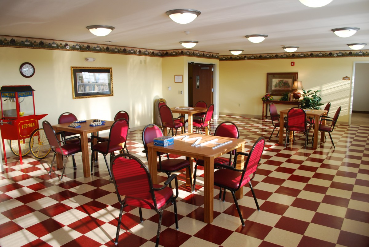 A dining area with red chairs and checkered flooring.