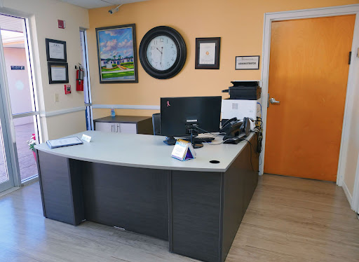A modern office workspace featuring a desk with a computer and decorative elements on the walls.