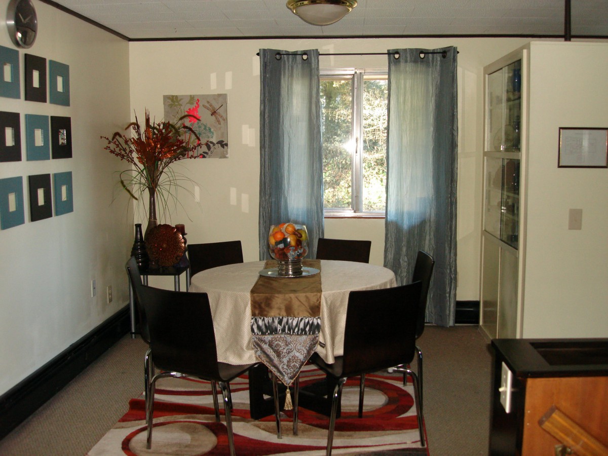 A cozy dining room with a round table, chairs, and decorative elements.