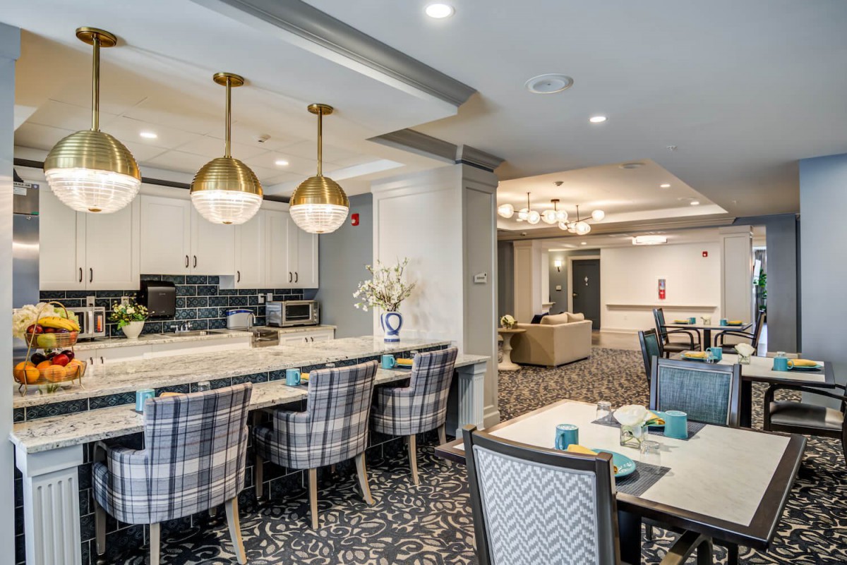 A luxurious dining area with modern decor, featuring an open kitchen and elegant seating.