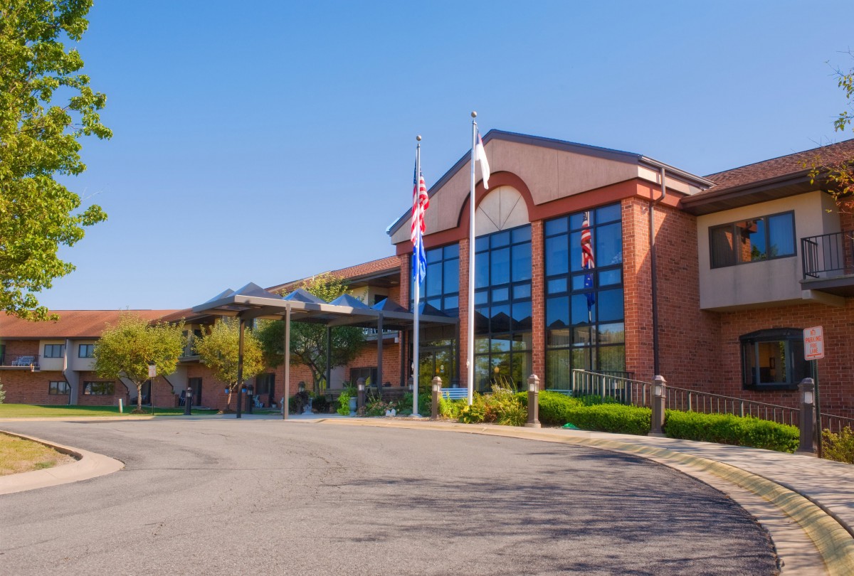 A modern hospital building with flags at the entrance.