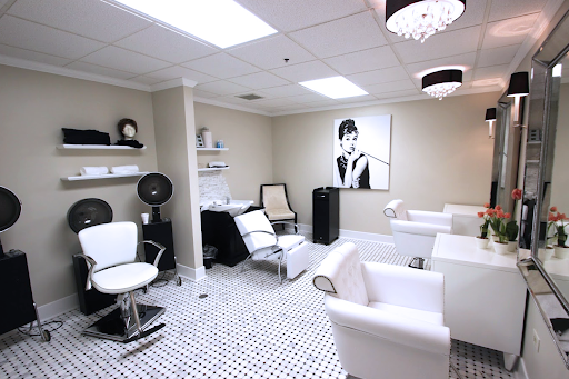 A modern and stylish beauty salon featuring sleek white furniture and elegant decor.