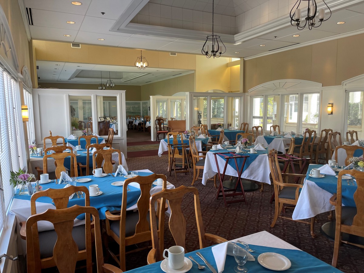 An elegant dining room with neatly arranged tables and chairs, prepared for guests.