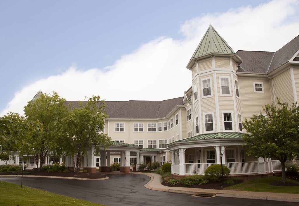 A Victorian-style residential building with a tower and landscaped surroundings.