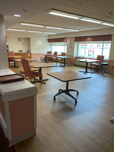 A spacious and bright room with tables and chairs, designed for gatherings or activities.