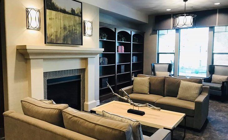 A cozy living room featuring a fireplace, comfortable sofas, and built-in bookshelves.