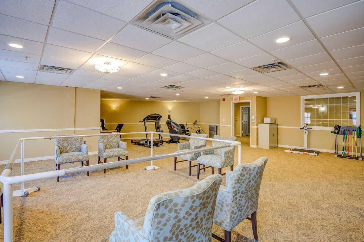 A spacious exercise room with fitness equipment and seating area.