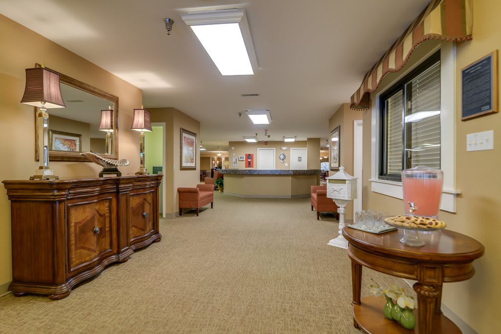 A warmly lit reception area with comfortable seating and a central desk.