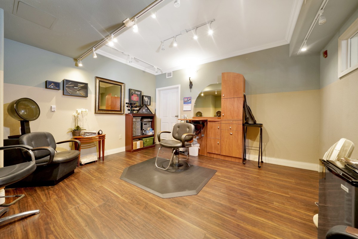 A modern hair salon interior with stylish furniture and a central styling chair.