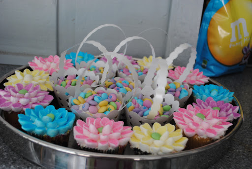 A delightful assortment of colorful cupcakes decorated with flower designs, perfect for a festive occasion.