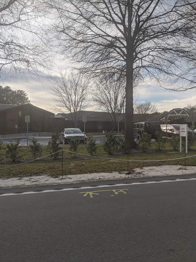 A view of a residential building surrounded by trees and a street.