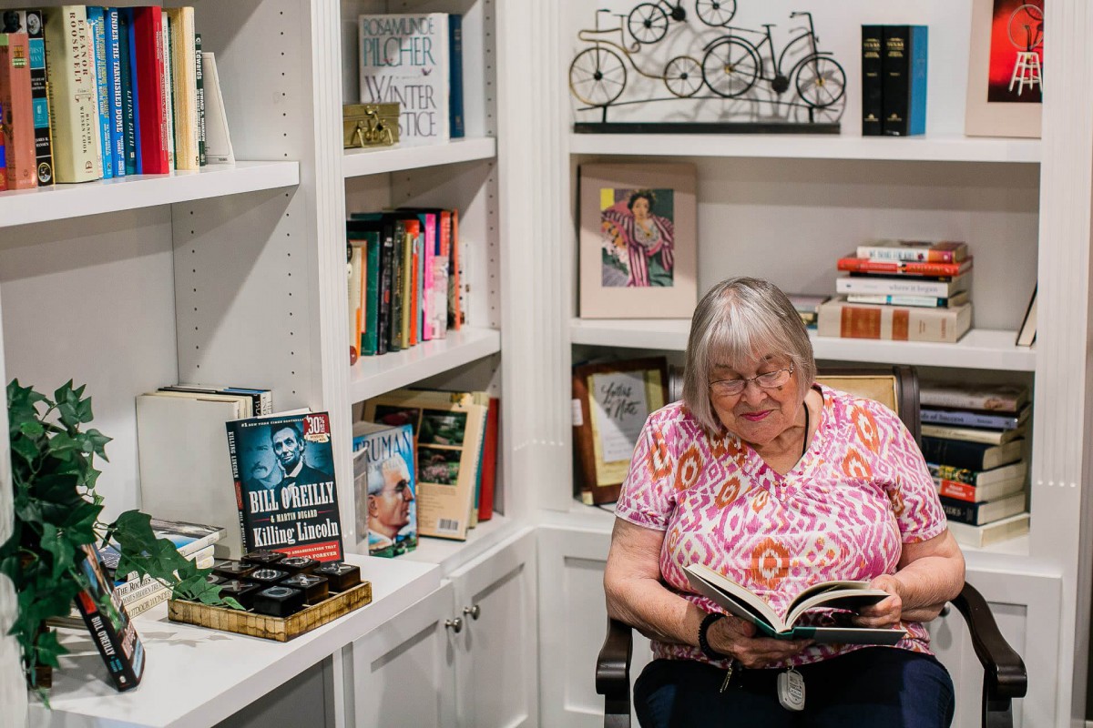 A woman reading a book in a cozy library corner.