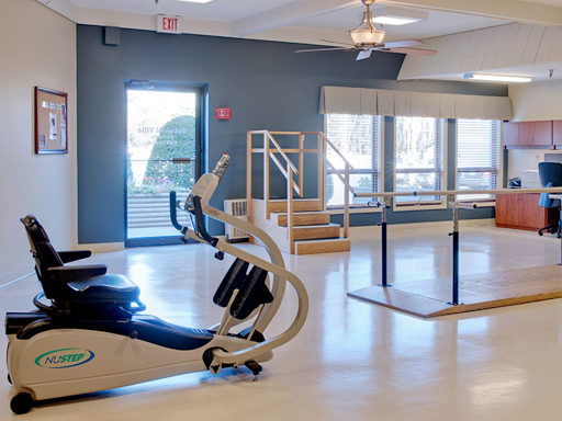 A bright and modern rehabilitation space equipped with exercise equipment and a ballet barre.