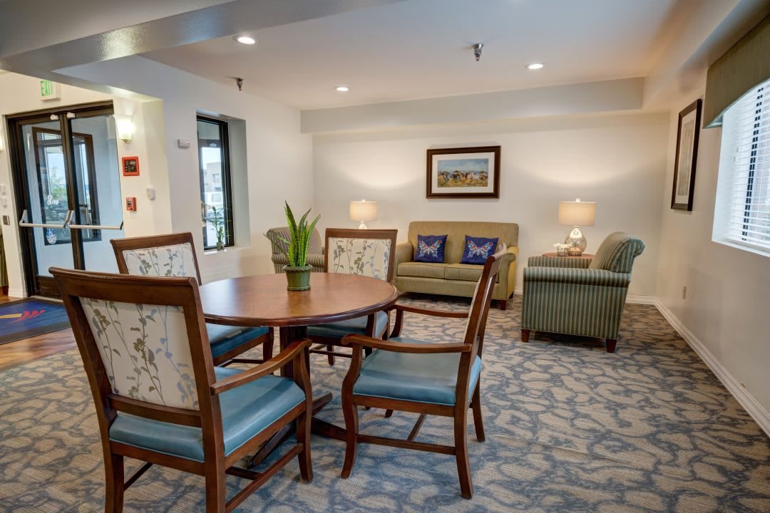 A cozy living room featuring a table with chairs, two sofas, and warm lighting.