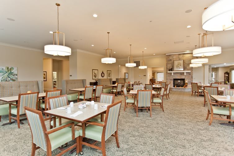 A spacious and well-lit dining area with neatly arranged tables and chairs.