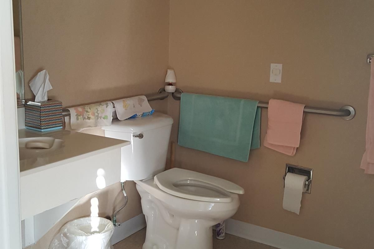 A clean bathroom with a toilet, sink, and towels.