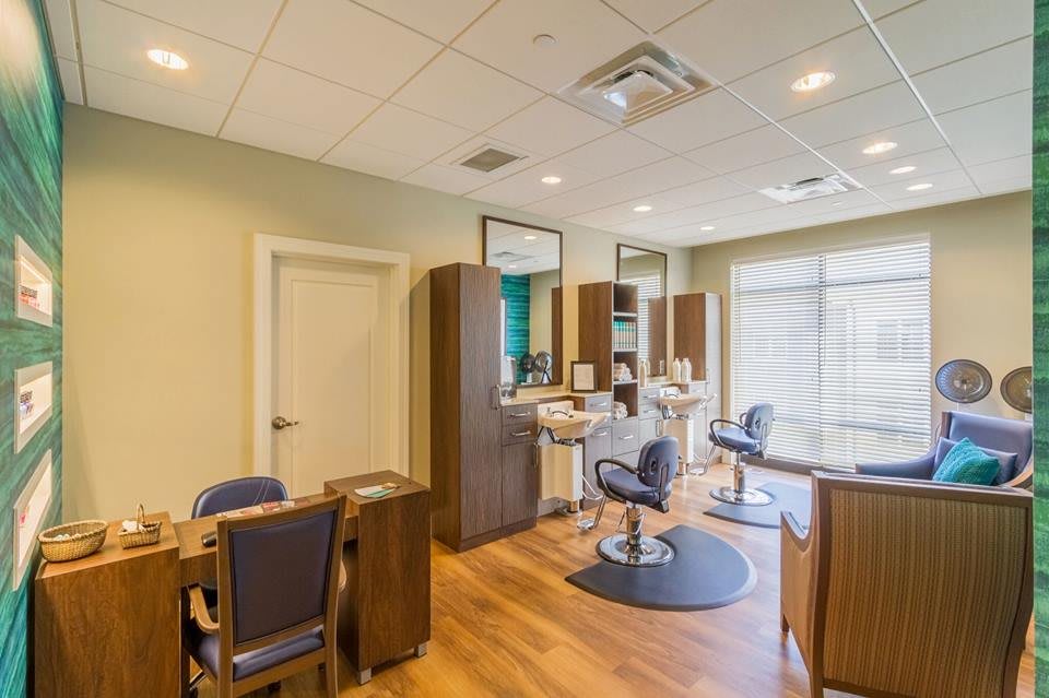 A modern salon interior with hairdressing stations and wood flooring.