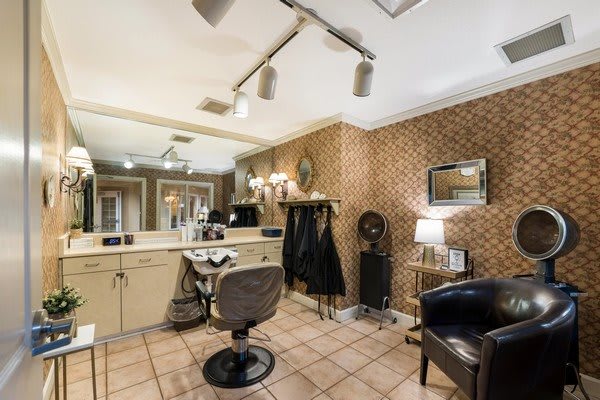 A well-lit hair salon interior with a barber chair, mirror, and stylish decor.