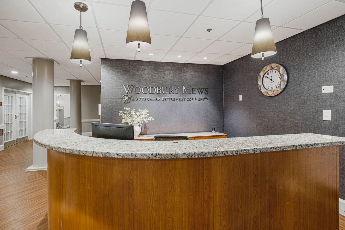 Modern reception area with a curved front desk and elegant lighting.