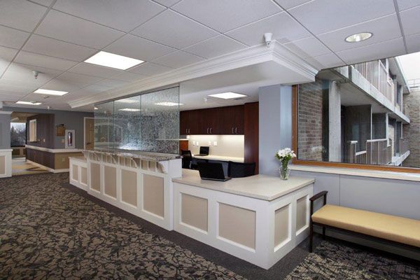 A modern office reception area with a front desk and comfortable seating.