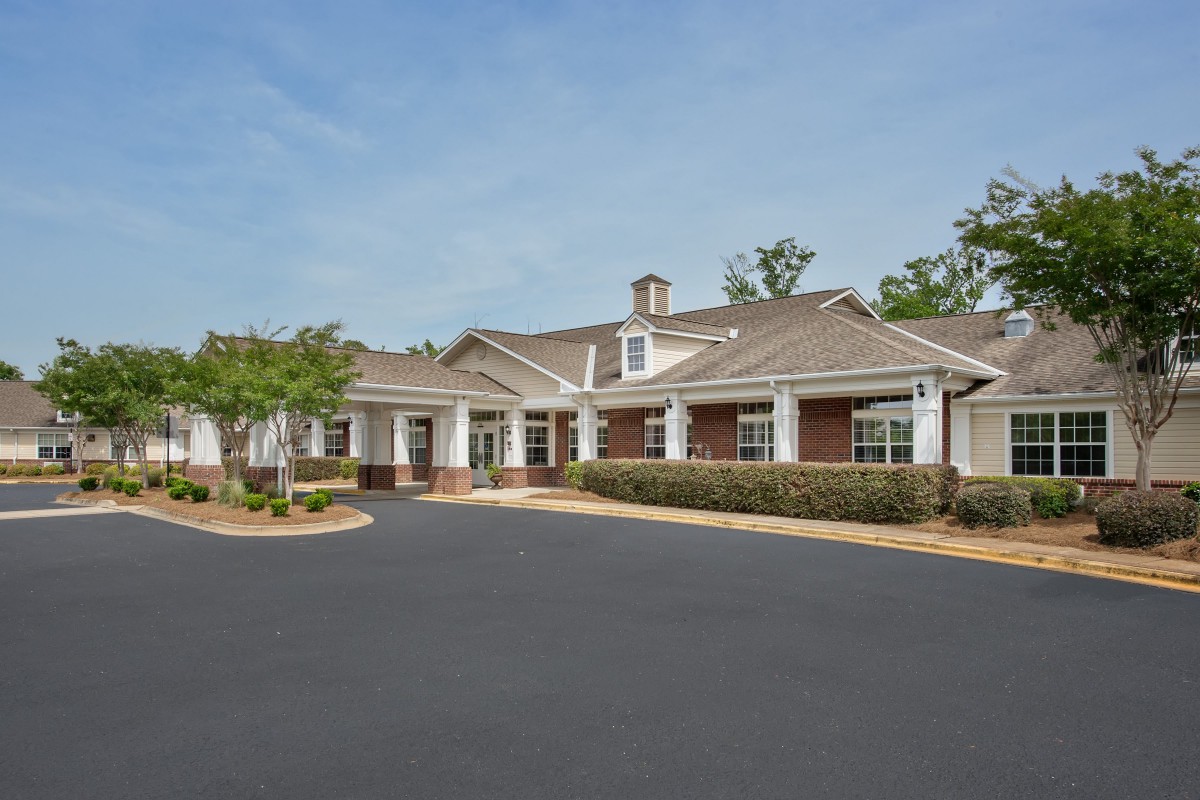 A residential building with a well-maintained driveway and clear blue sky.