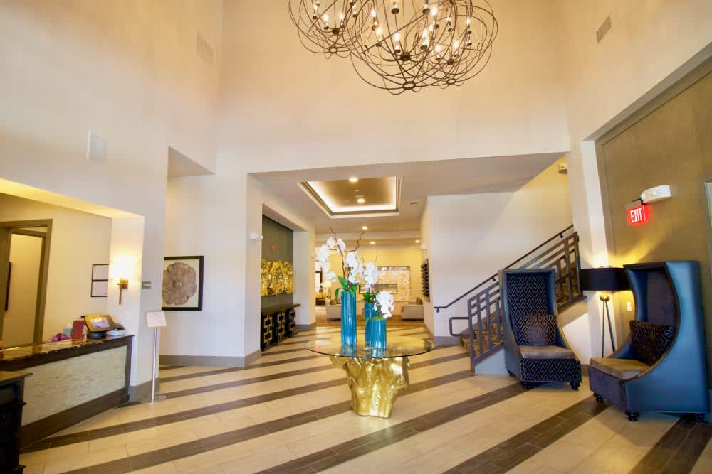 A modern hotel lobby featuring a large chandelier and elegant interior design elements.