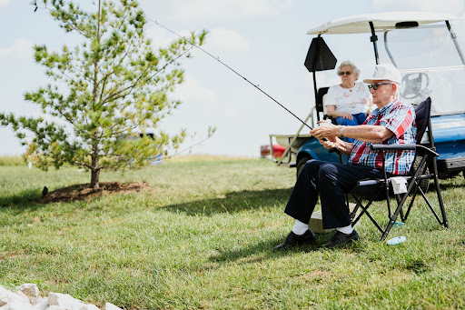 A serene scene of two seniors enjoying a day of fishing in the great outdoors.