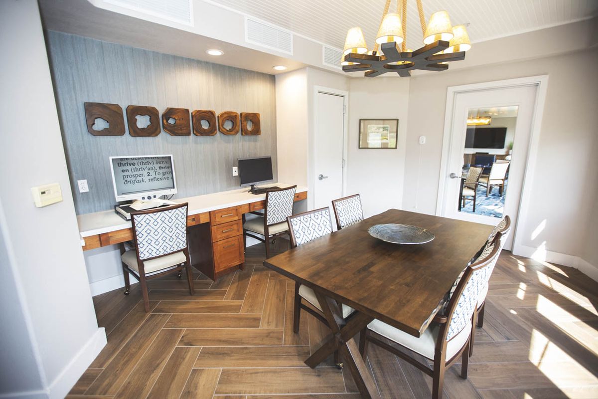 A modern home office with wooden furniture and computer workstations.