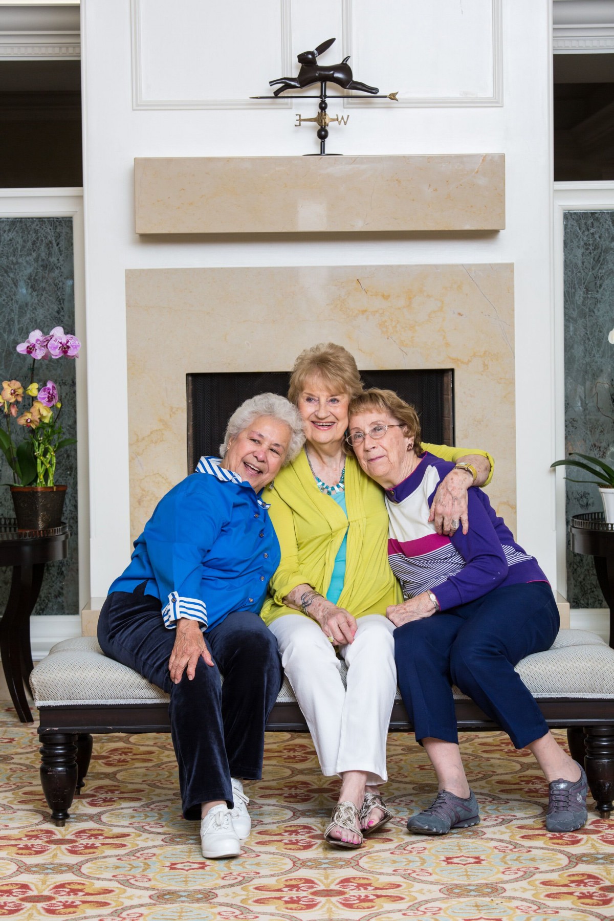 Three senior women enjoying each other's company in a cozy living room setting.