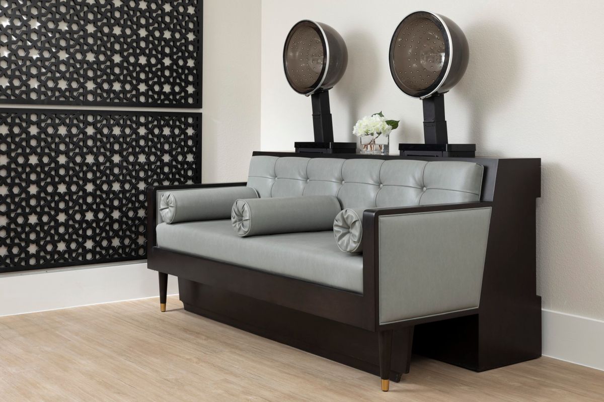 A modern salon interior featuring a sleek sofa with built-in hairdryers.