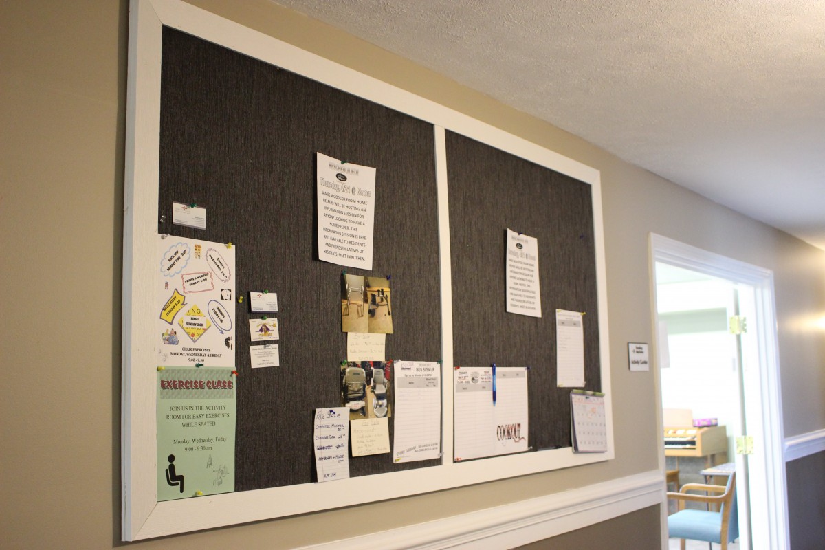 A community bulletin board with various notices and announcements pinned to it.