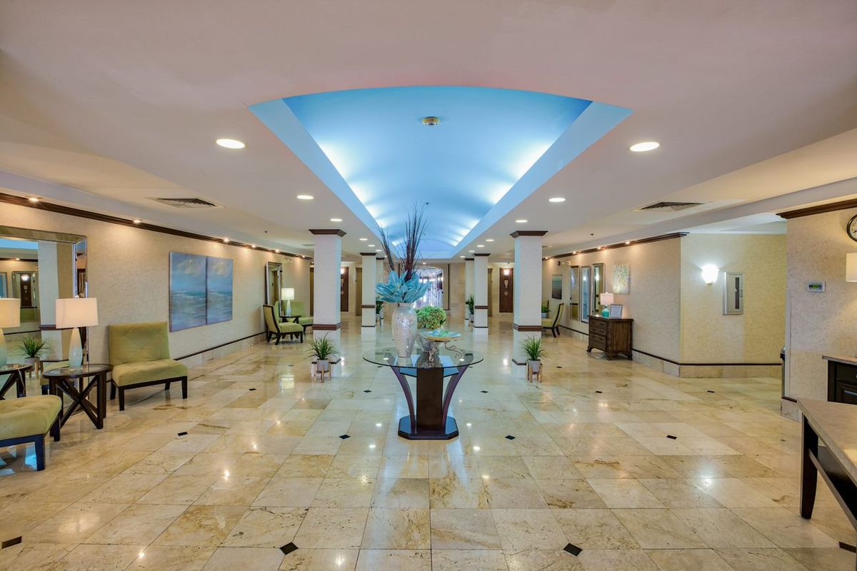 Spacious and modern hotel lobby with elegant marble flooring and soft lighting.
