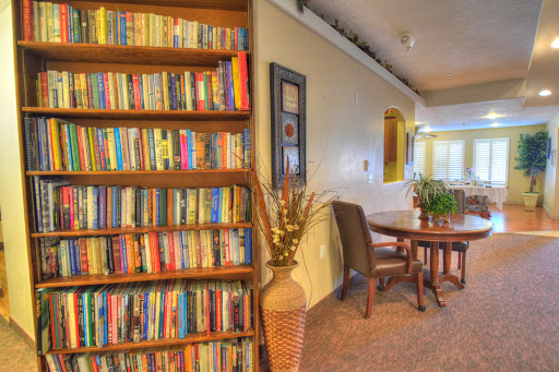 A cozy reading nook featuring a well-stocked bookshelf and a dining area, perfect for relaxation and gathering.