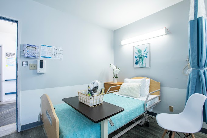 A clean and minimalist hospital room with a medical bed and essential furnishings.