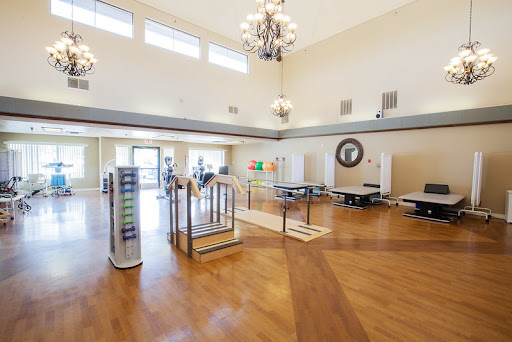 A spacious and well-lit therapy room equipped with modern rehabilitation equipment.