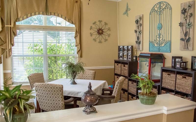 A cozy dining area with a table, chairs, and natural light streaming through the window.