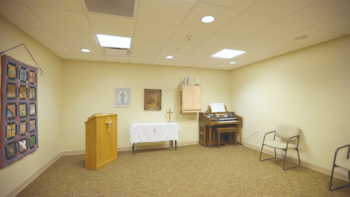 A quiet chapel space featuring a small altar and an organ.