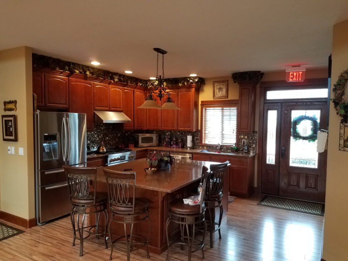Spacious kitchen with wooden cabinets, a central island, and modern appliances.