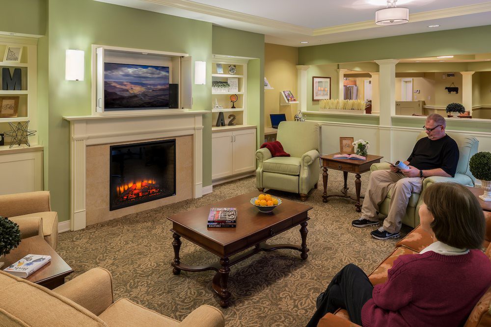 A cozy living room with a fireplace, comfortable seating, and a television.