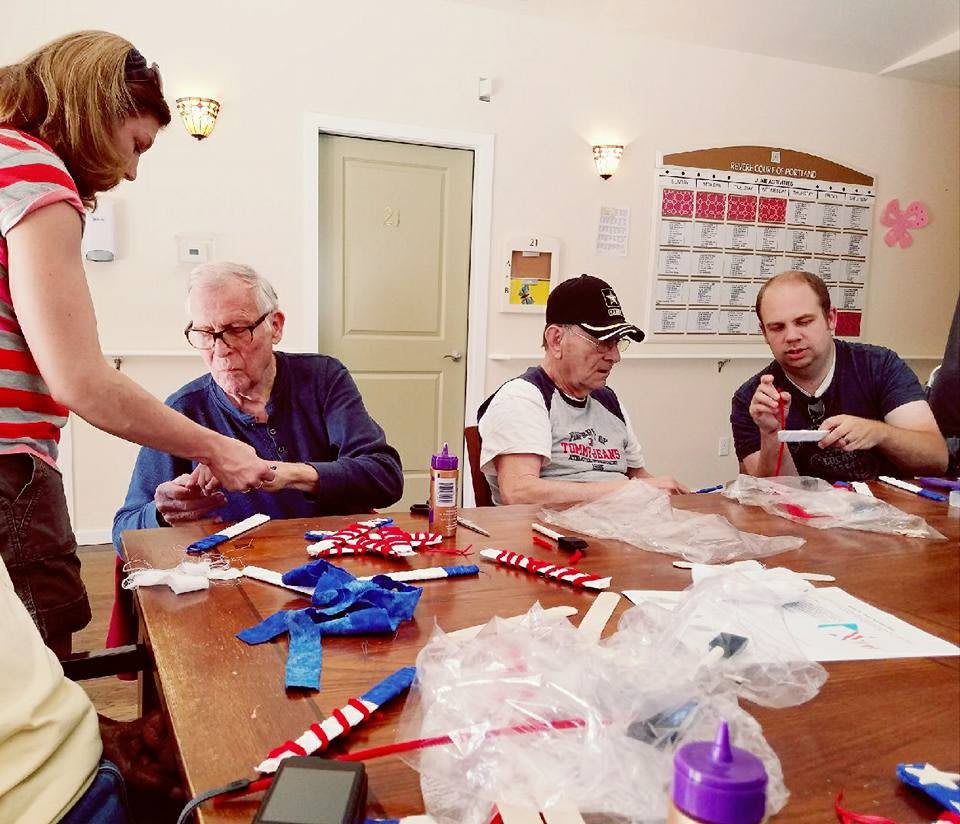 A group of people engaging in a crafting activity at a community center.