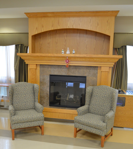 A cozy living room setting with two comfortable chairs facing a wooden fireplace.