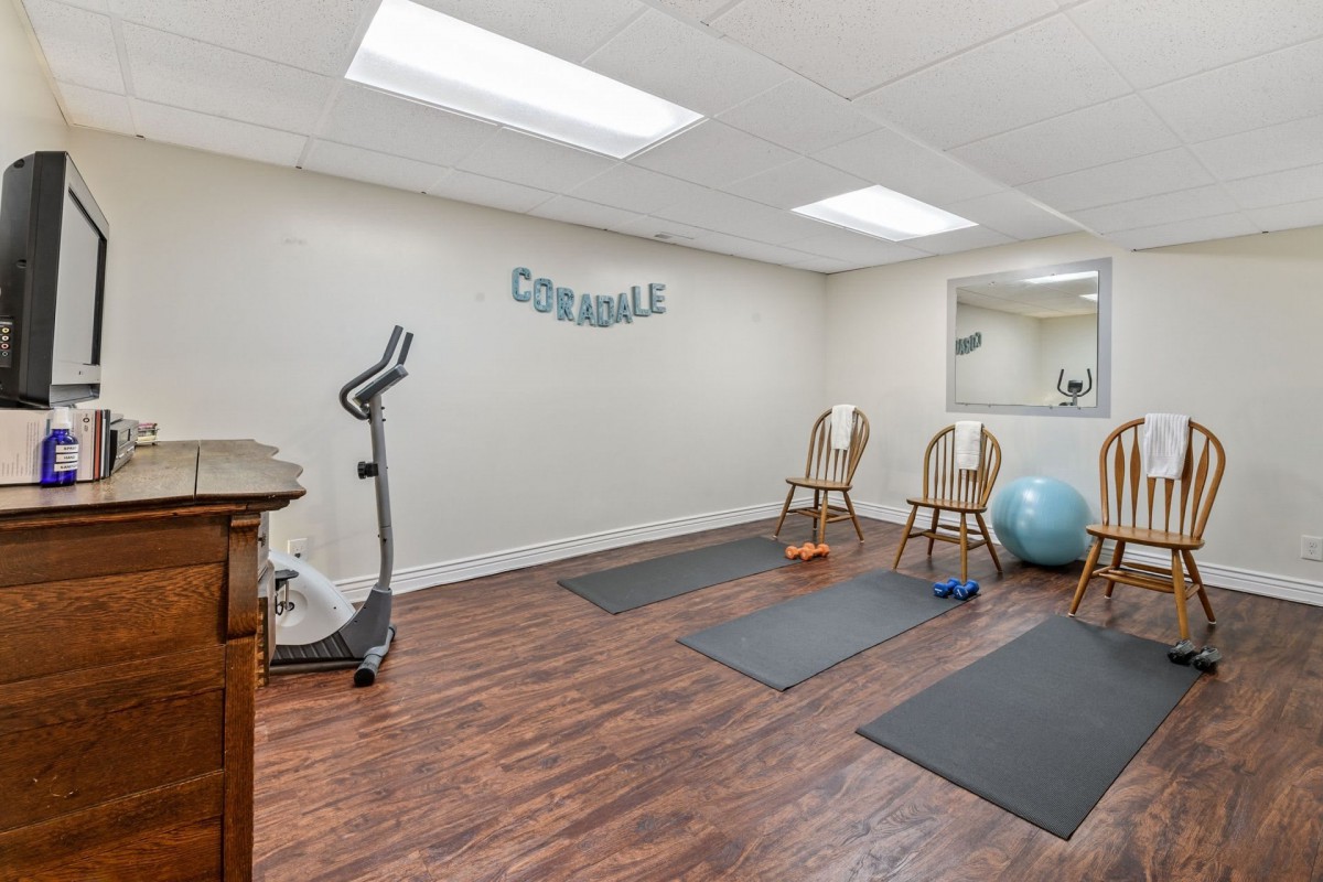 A well-equipped exercise room with yoga mats, a stationary bike, and fitness accessories.