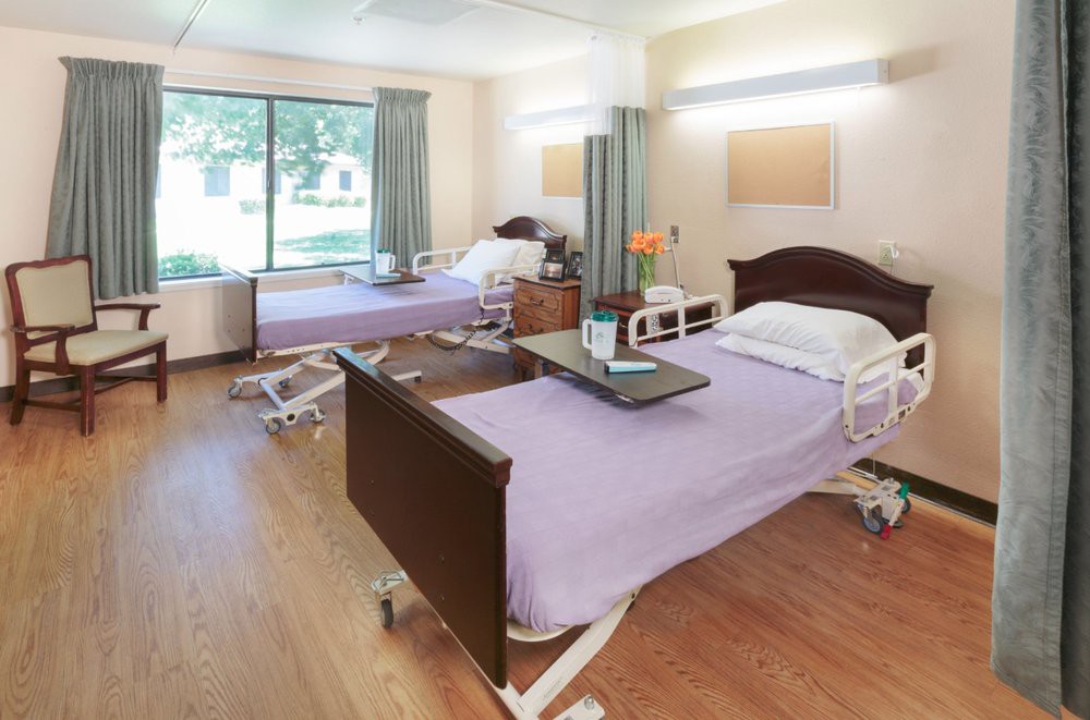 A clean and well-organized hospital room with two patient beds.