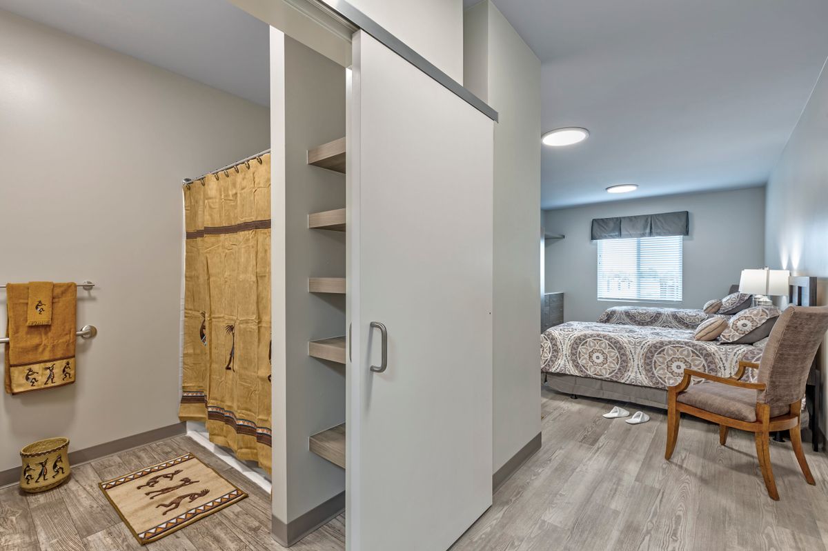 A modern bedroom with a sliding door and built-in shelves.