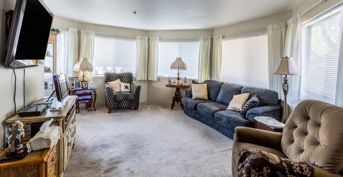 A cozy living room with a sofa, armchair, and multiple lamps.
